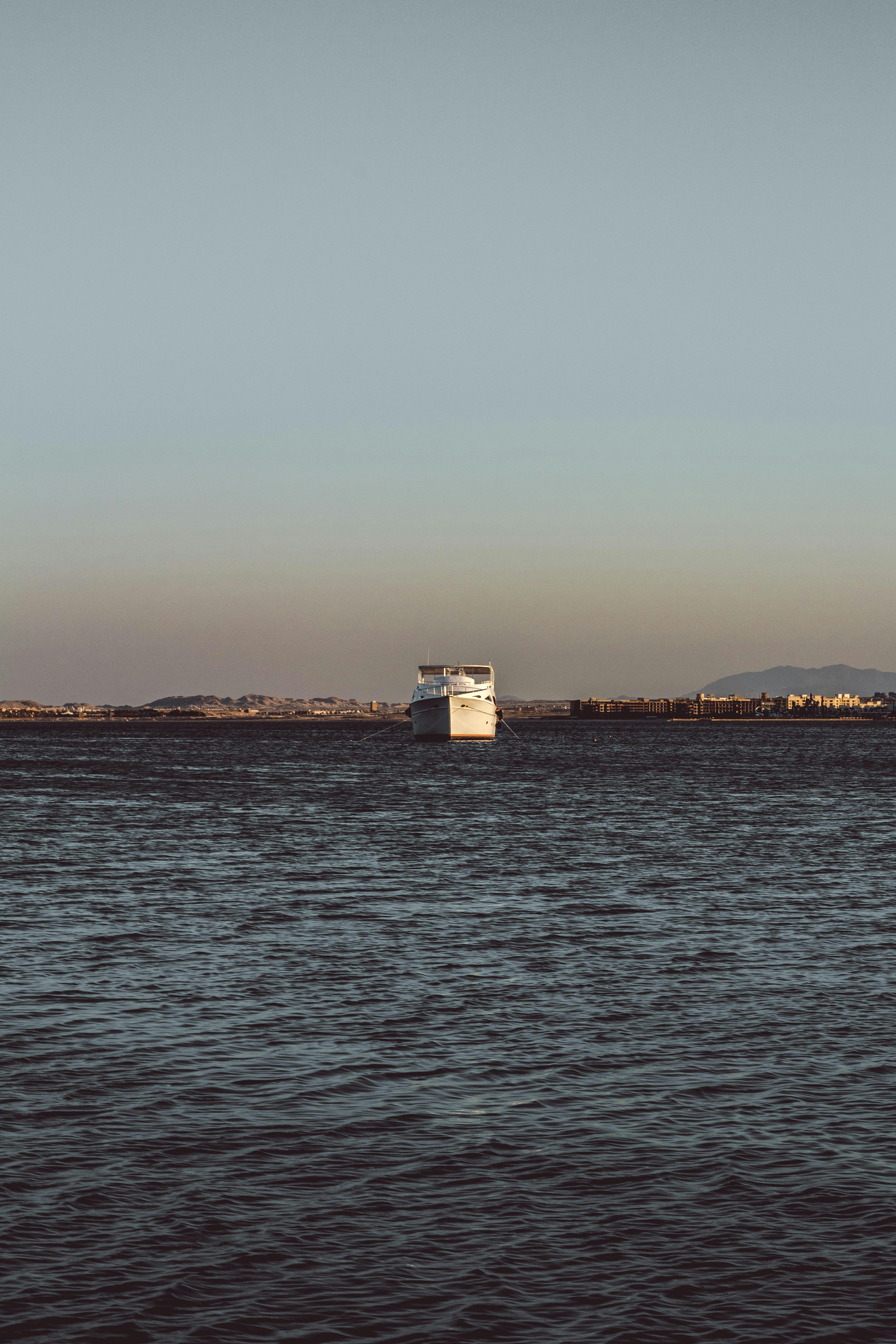 white lighthouse near body of water during daytime